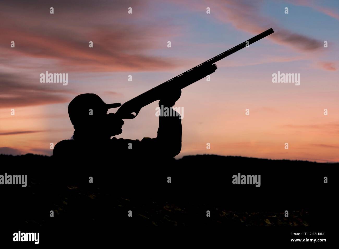 Mann, der im Morgengrauen Enten schießt Stockfoto