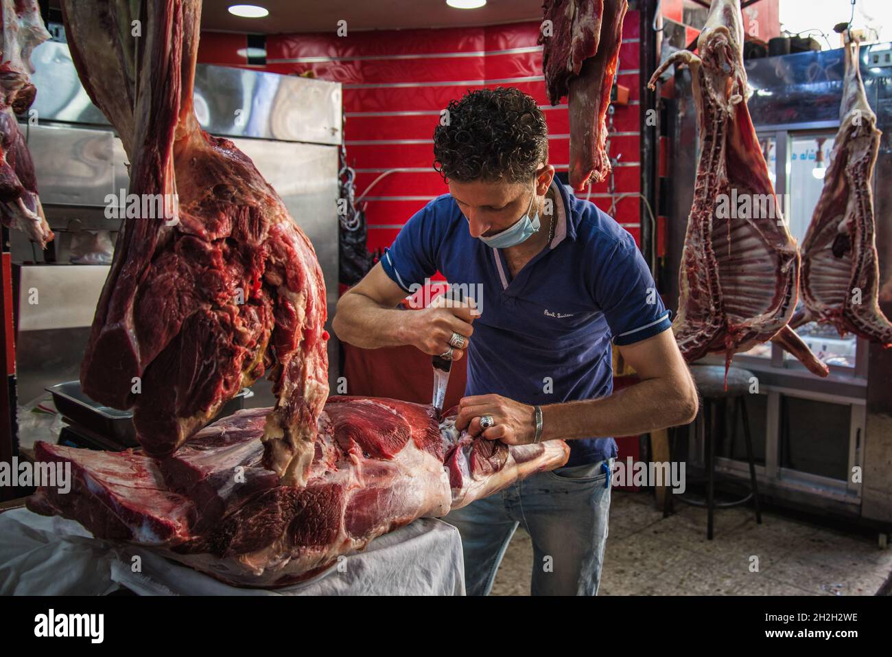 Amman, Jordanien - 06 2021. Oktober: Markt in der Innenstadt in der Hauptstadt Amman, Metzger schneidet Fleisch in seinem Laden Stockfoto