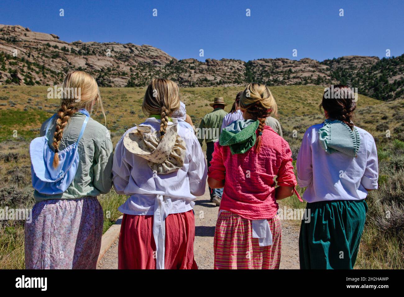 Teenager-Mädchen in Pioneer drees führen eine mormonische Pionierhandkarre entlang des Mormon Trail in Wyoming wieder auf. Stockfoto