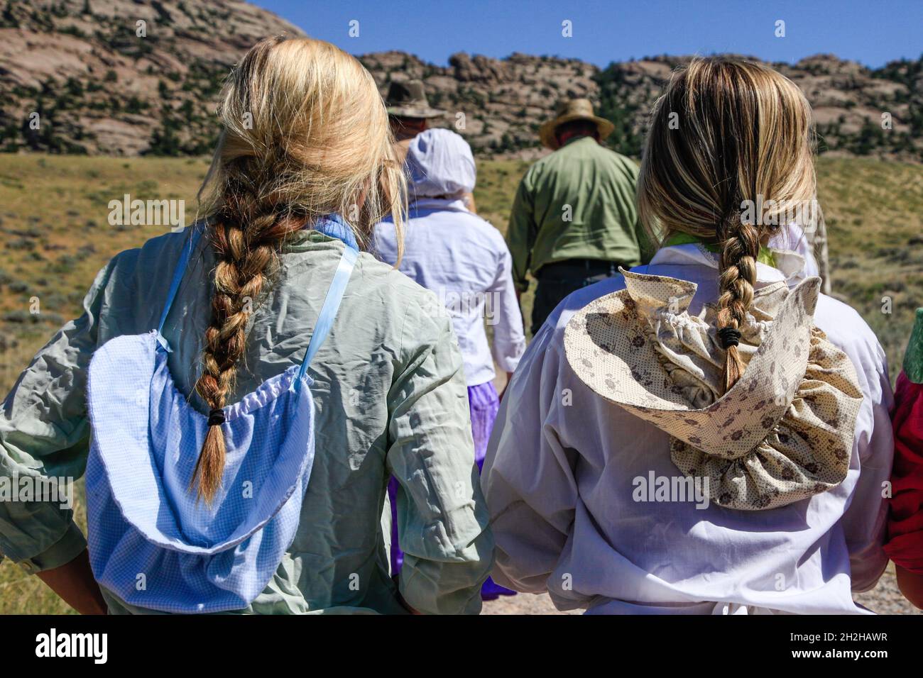 Teenager-Mädchen in Pioneer drees führen eine mormonische Pionierhandkarre entlang des Mormon Trail in Wyoming wieder auf. Stockfoto