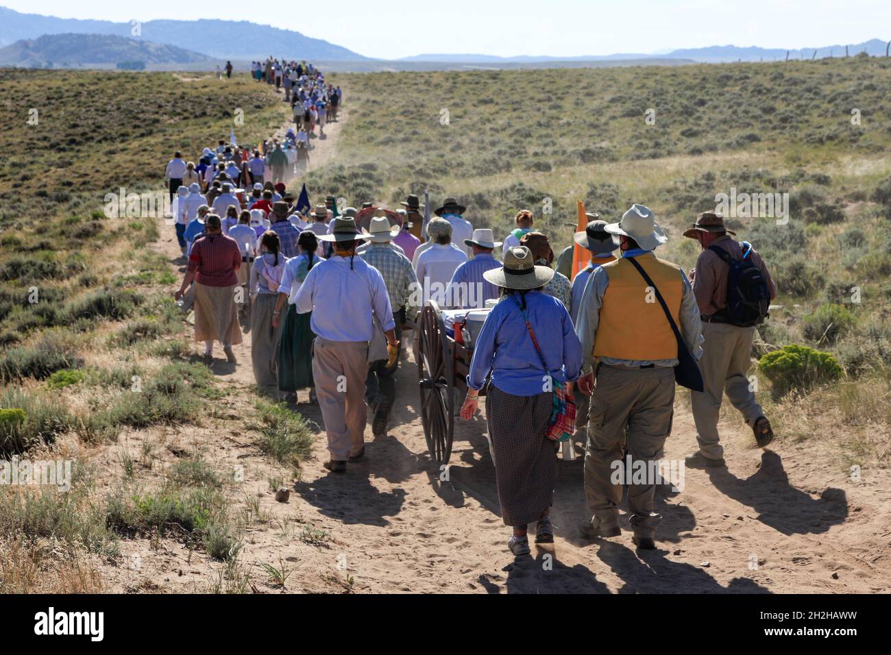 Eine Gruppe von jungen Leuten und Führern im Teenageralter reenact eine mormonische Pionierhandkarren-Wanderung auf den Ebenen von Wyoming. Stockfoto