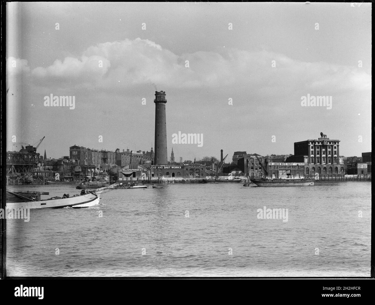 Shot Tower and Lead Works, Belvedere Road, Lambeth, Greater London Authority, 1936. Ein Blick über die Themse in Richtung des Schrotturms bei Lambeth Lead Works mit der Lion Brewery auf der rechten Seite. Der Schussturm der Lambeth-Hauptwerke wurde von David Ridall Roper entworfen und 1826 für Thomas Maltby &amp; Co. Erbaut. Zum Zeitpunkt dieser Aufnahme wurde er von Walkers, Parker &amp; Co, aber es wurde später im Jahr 1962 abgerissen, um Platz für die Queen Elizabeth Hall zu machen. Die Lion Brewery wurde 1836-37 erbaut, wurde aber 1949 abgerissen, um Platz für die Royal Festival Hall zu schaffen. Stockfoto