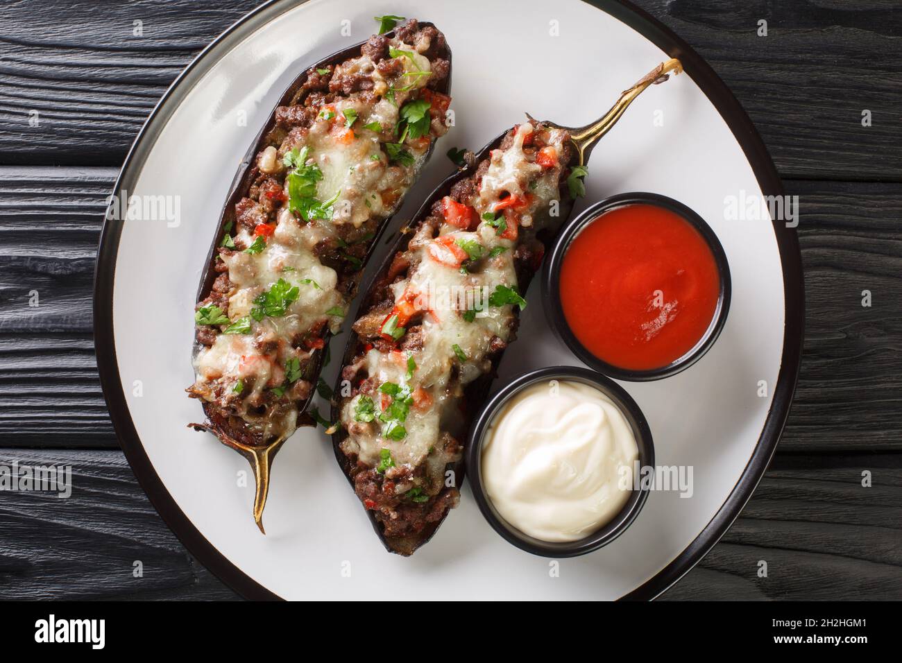 Berenjena rellena Spanish gefüllte Aubergine mit Hackfleisch, Gemüse und Käse Nahaufnahme in einem Teller auf dem Tisch. Horizontale Draufsicht von oben Stockfoto