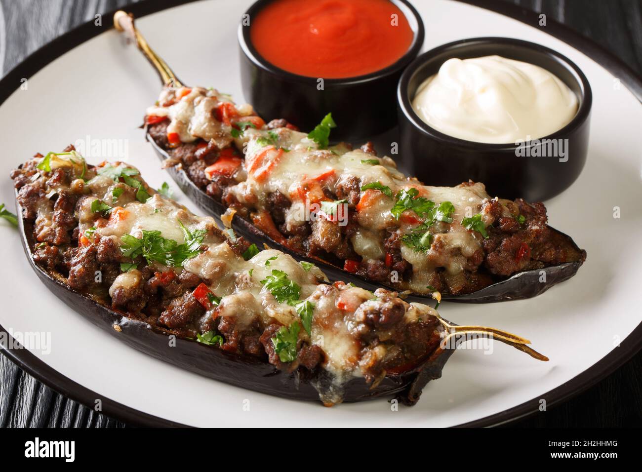 Berenjena rellena Spanish gefüllte Aubergine mit Hackfleisch, Gemüse und Käse Nahaufnahme in einem Teller auf dem Tisch. Horizontal Stockfoto