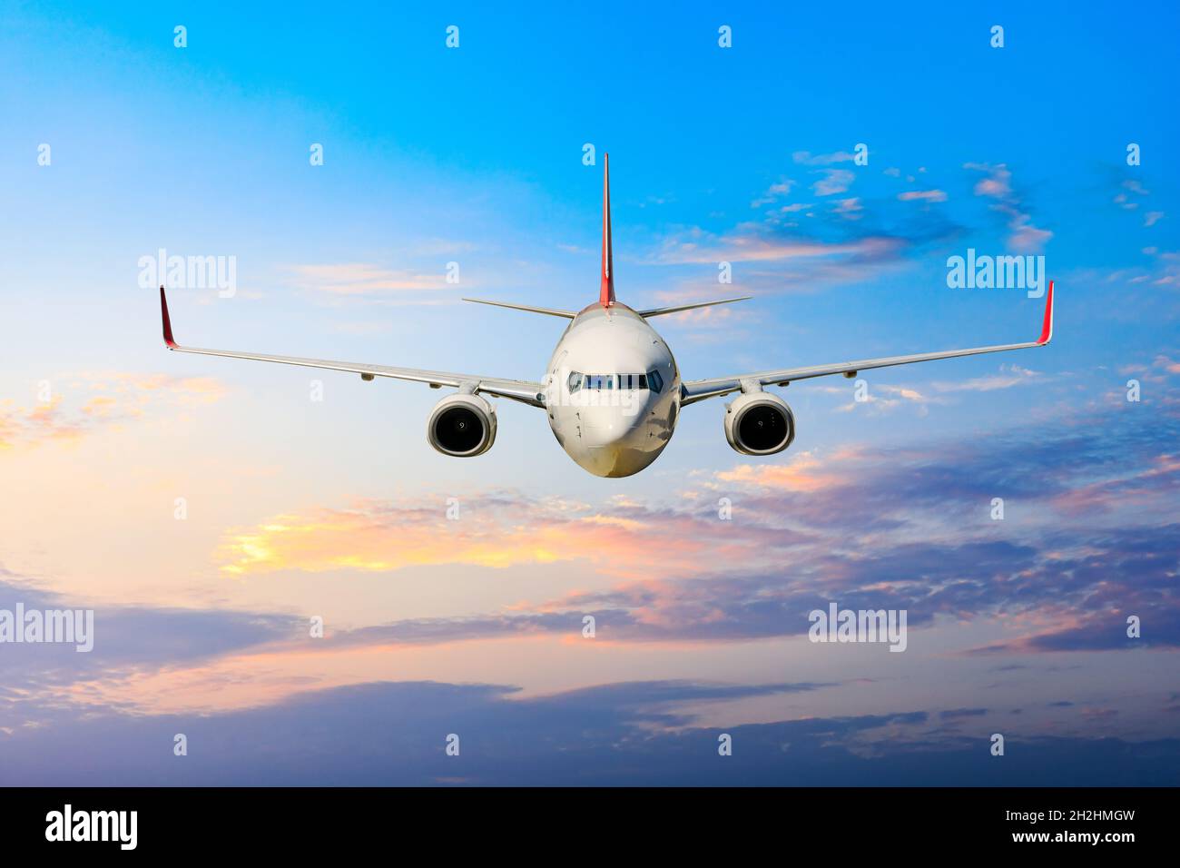 Verkehrsflugzeug, das über Wolken im farbenfrohen Sunset.Travel, Urlaub und Business-Konzept fliegt. Stockfoto