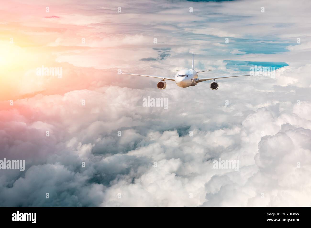Verkehrsflugzeug, das über Wolken im farbenfrohen Sunset.Travel, Urlaub und Business-Konzept fliegt. Stockfoto