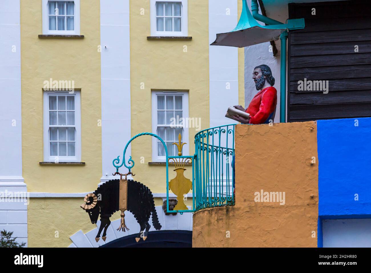 Portmeirion Dorf, Gwynedd, Nordwales - Statue von St. Peter predigen und schwarzen Widder Schafe Zeichen auf toll House - Touristendorf Stockfoto