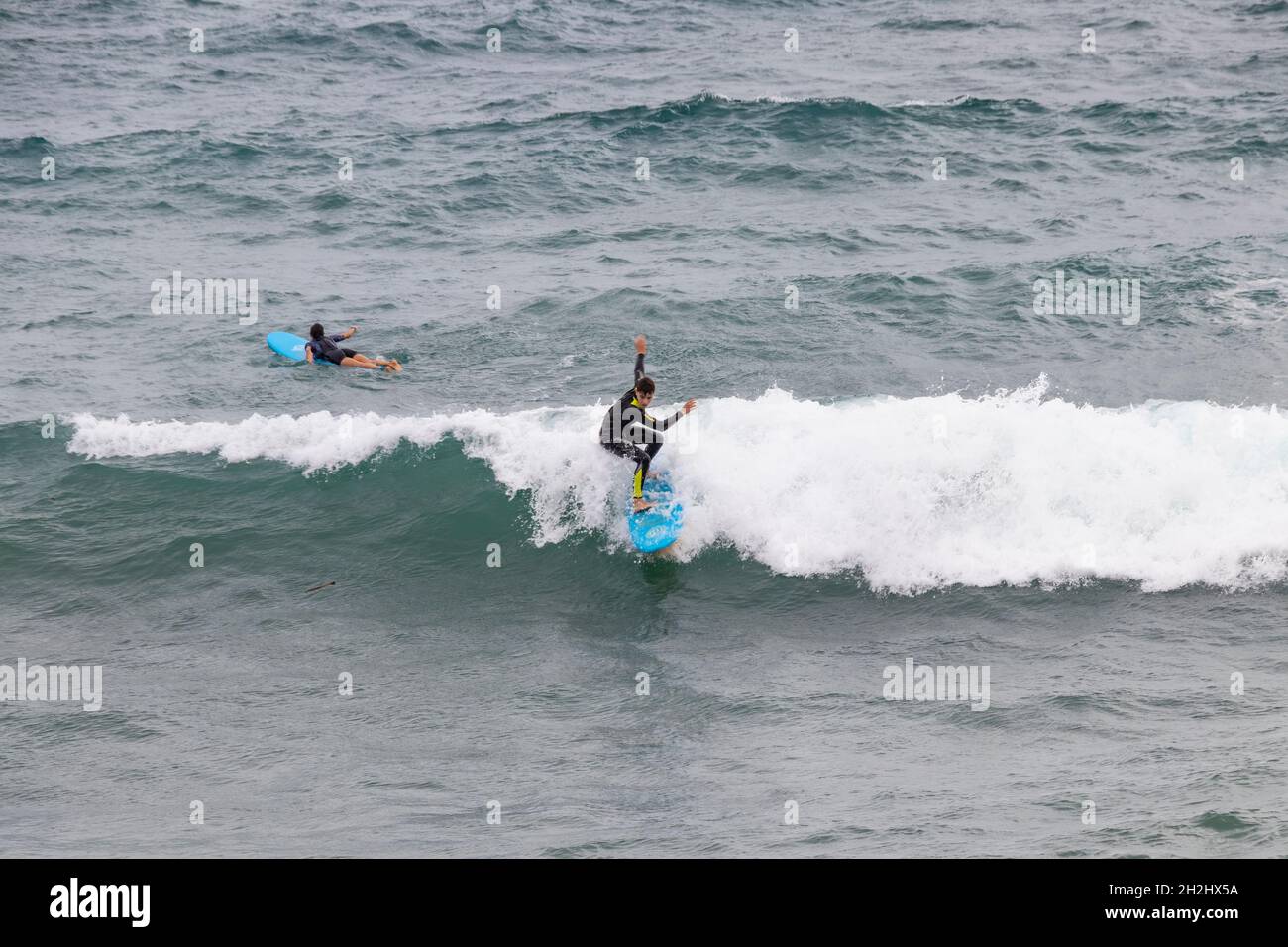 Barcelona, Spanien - 24. September 2021: Wetsuit Surfer fangen eine Welle Stockfoto