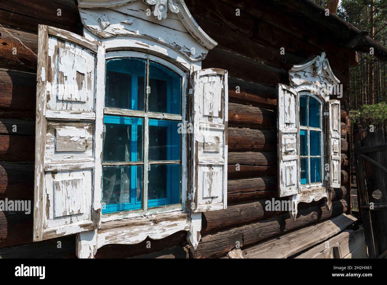 Traditionelles Holzhaus mit weißen Fenstern und Fensterläden im Ethnographischen Freilichtmuseum in der Nähe von Ulan-Ude. Republik Burjatien, Russland Stockfoto