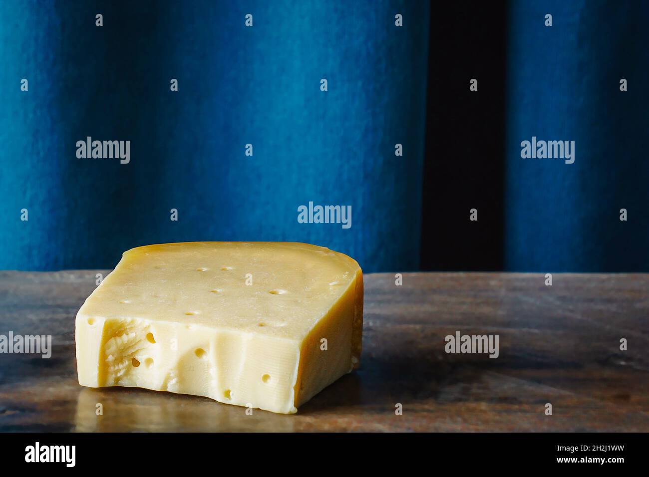 cheddar-Käsestück auf Holztisch Stockfoto