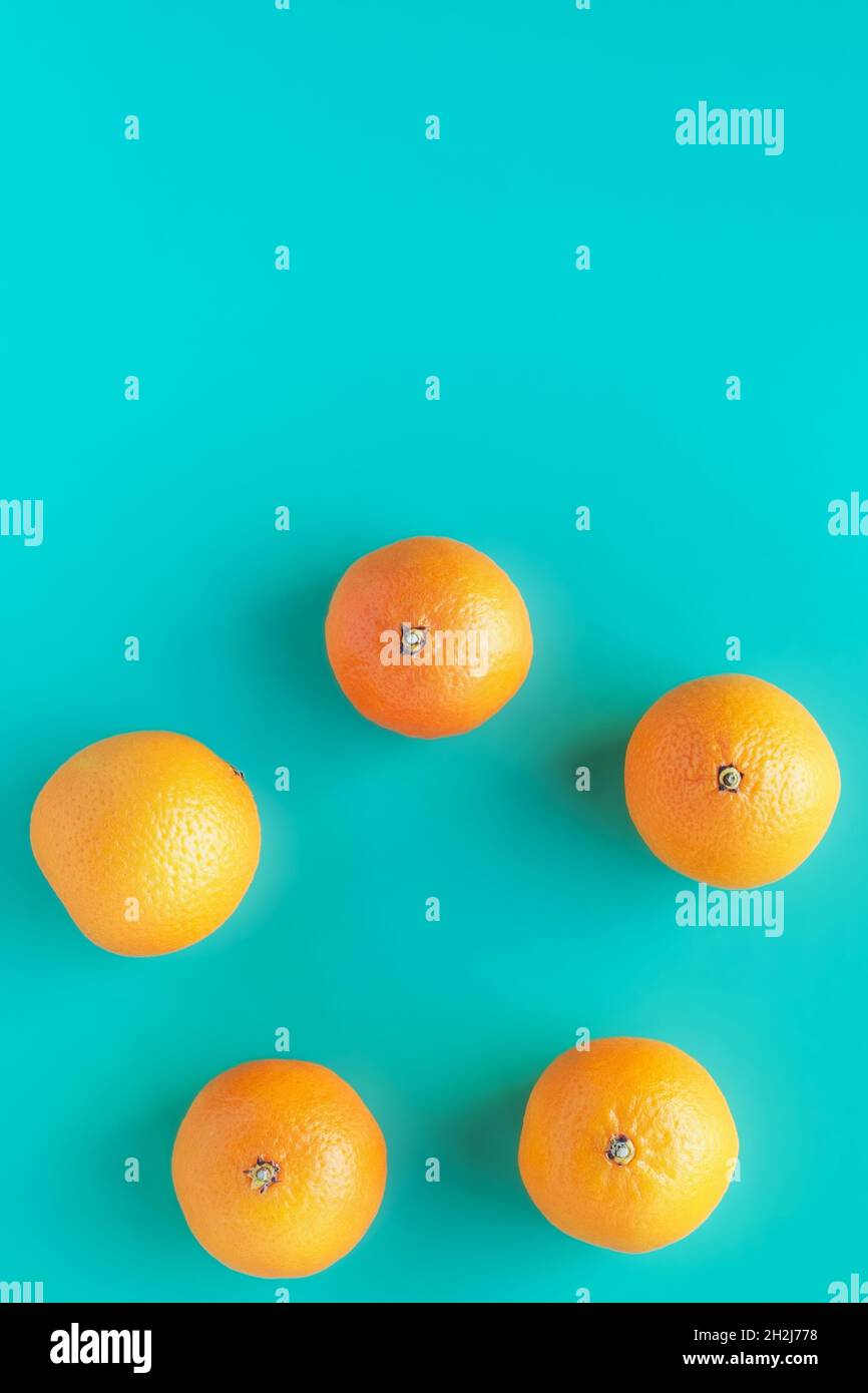 Kreis mit Zitrusfrüchten. Orange saftige Mandarinen auf türkisfarbenem Hintergrund. Stockfoto
