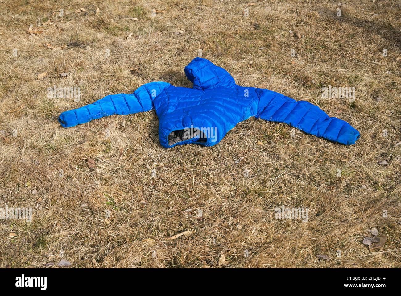 Blau gepolsterte Jacke auf dem Boden liegend Stockfoto