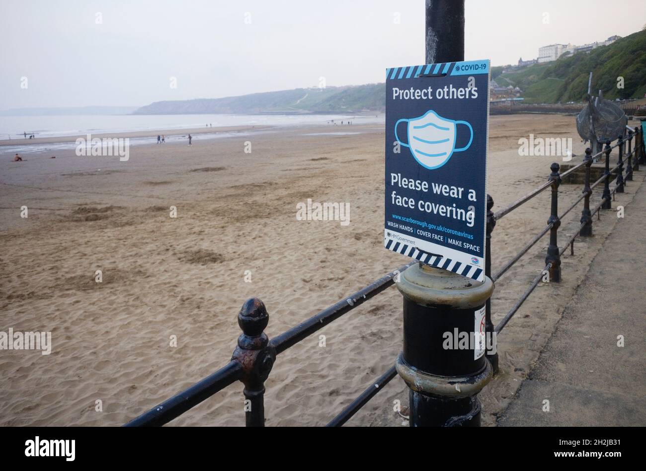 Schilder an der Küste von Scarborough, auf denen die Leute aufgefordert werden, am Strand eine Gesichtsbedeckung zu tragen Stockfoto