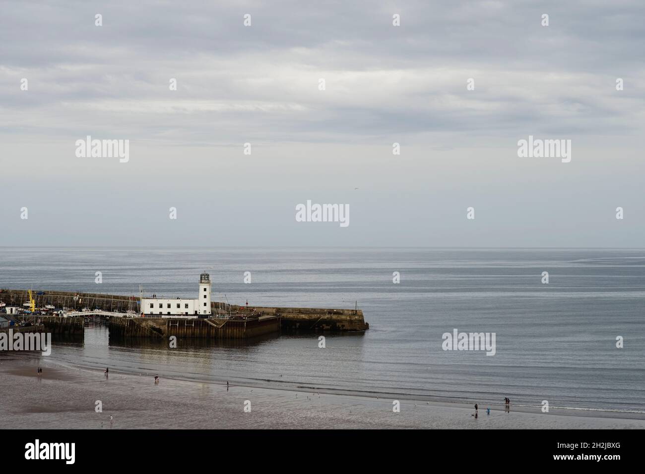 Blick auf die Nordsee mit dem Hafen von Scarborough und dem Leuchtturm im Vordergrund Stockfoto