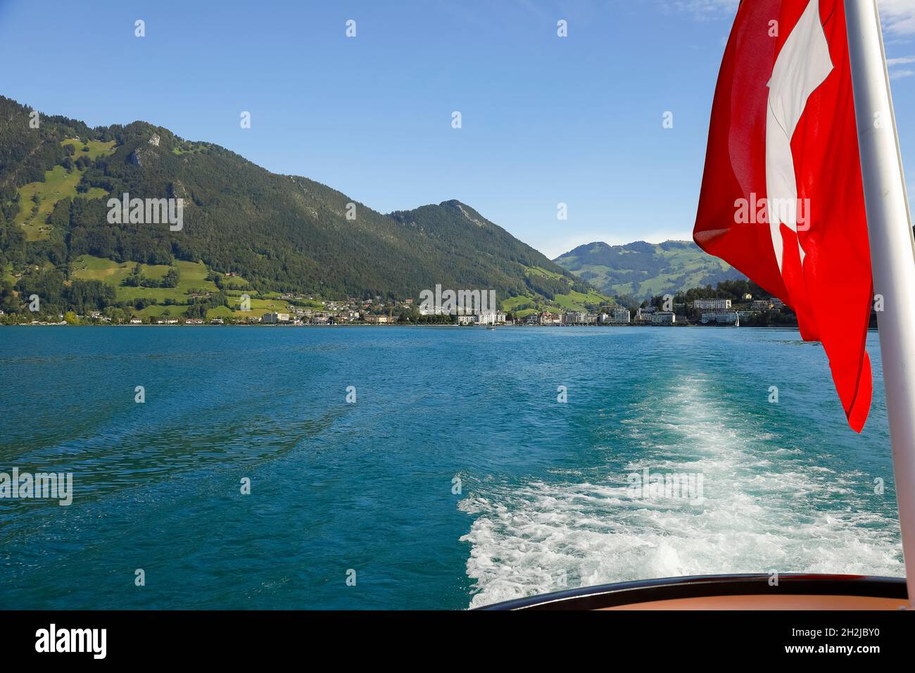 Die Flagge der Schweiz auf dem Mast ist vor dem Hintergrund einer malerischen Landschaft zu sehen. Stockfoto