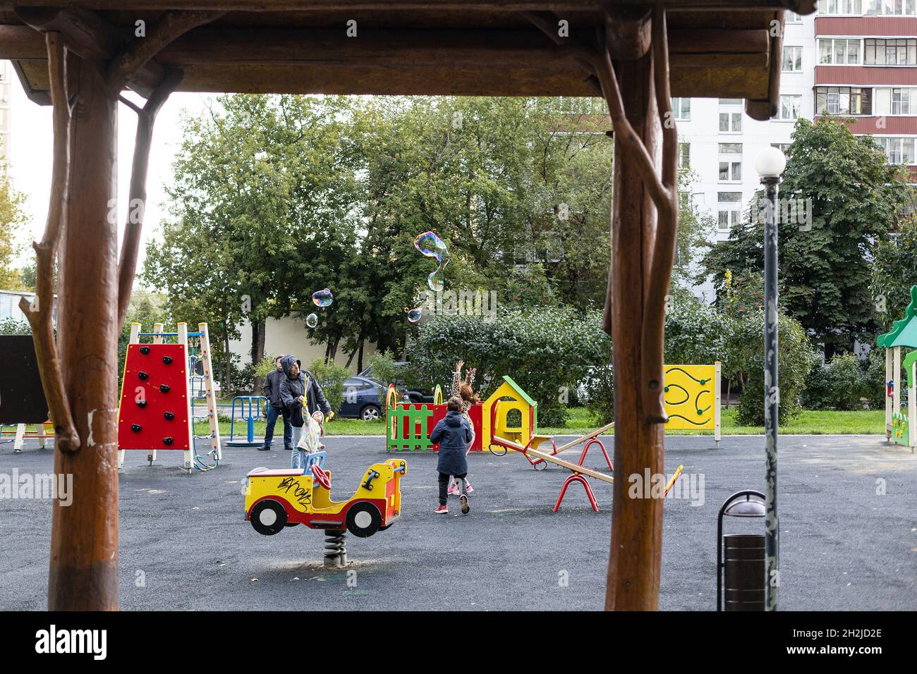 Moskau, Russland - 4. September 2021: Kinder blasen mit ihrem Vater auf dem Spielplatz im Innenhof der Stadt im Wohnviertel von Moskau c Stockfoto