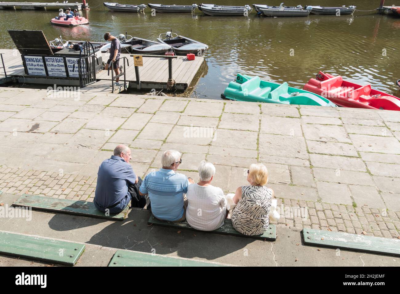 Menschen sitzen reden und beobachten Flussbootaktivitäten River Dee Chester 2021 Stockfoto