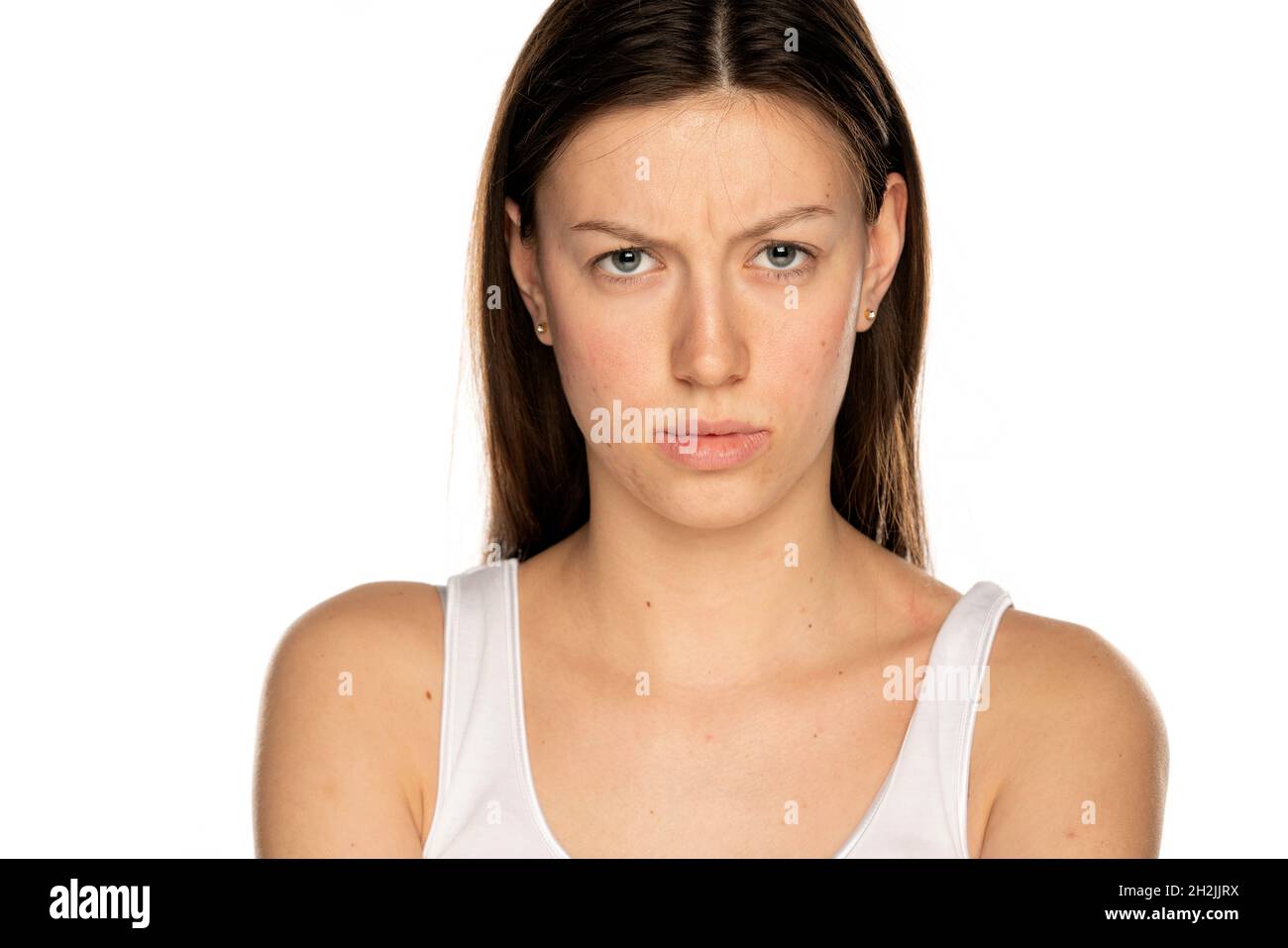 Wütende junge Frau ohne Make-up, auf weißem Hintergrund Stockfoto