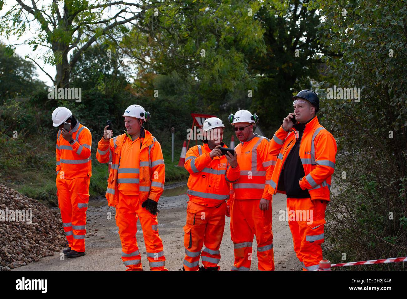 Chalfont St Peter, Großbritannien. Oktober 2021. Stopp HS2-Demonstranten aus dem Kriegslager Wendover aktiver Widerstand besetzten einen Bagger, der heute vor dem Gelände des HS2 Chalfont St Peter Hochwasserschutzarbeiten durchführte, wo die Überschwemmungen auf der Straße angeblich viel schlimmer wurden, seitdem HS2 vor Ort Bäume und Felder geräumt hat. Es wurde berichtet, dass HS2 1,600 Kubikmeter potenziell stark verschmutzenden Bentonits in den Kalkaquifer am Standort verloren hat. Quelle: Maureen McLean/Alamy Live News Stockfoto