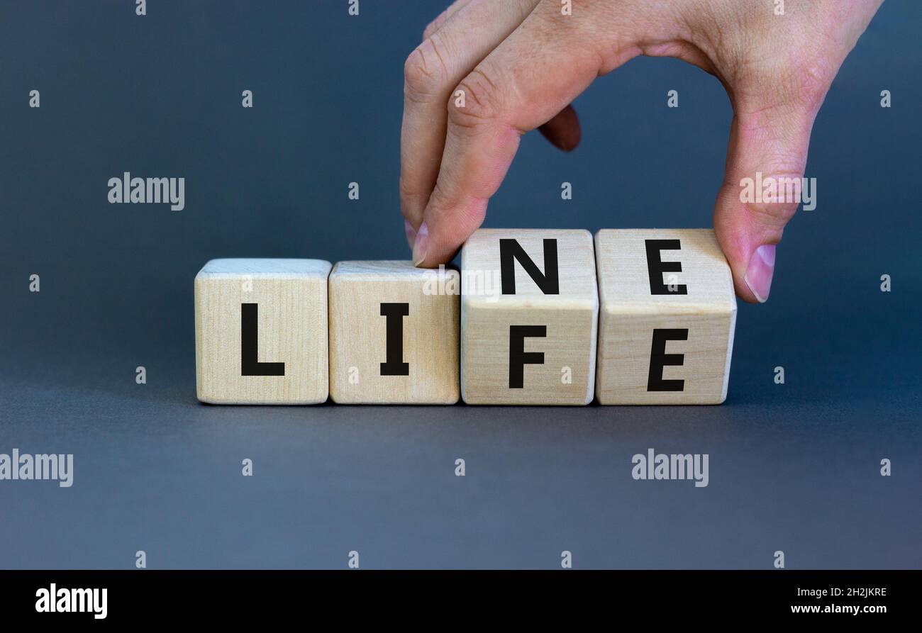 Lebensader, Lebenssymbol. Businessman Hand dreht Würfel und ändert das Wort "Leben" in "Linie". Schöner grauer Hintergrund. Geschäftsleben, Linie Stockfoto