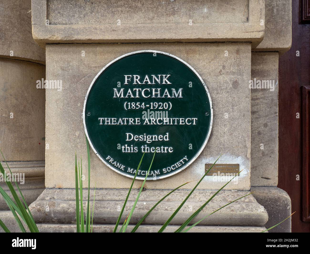 Grüne Gedenktafel an den Theaterarchitekten Frank Matcham vor dem Opernhaus, Buxton, Derbyshire, Großbritannien Stockfoto