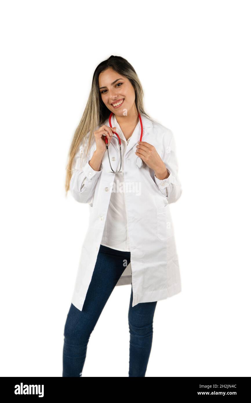 Junge Latina-Ärztin mit einem großen Lächeln, die das Stethoskop auf weißem Hintergrund hält. Konzept der professionellen Frau, Gesundheitspersonal. Ameri Stockfoto
