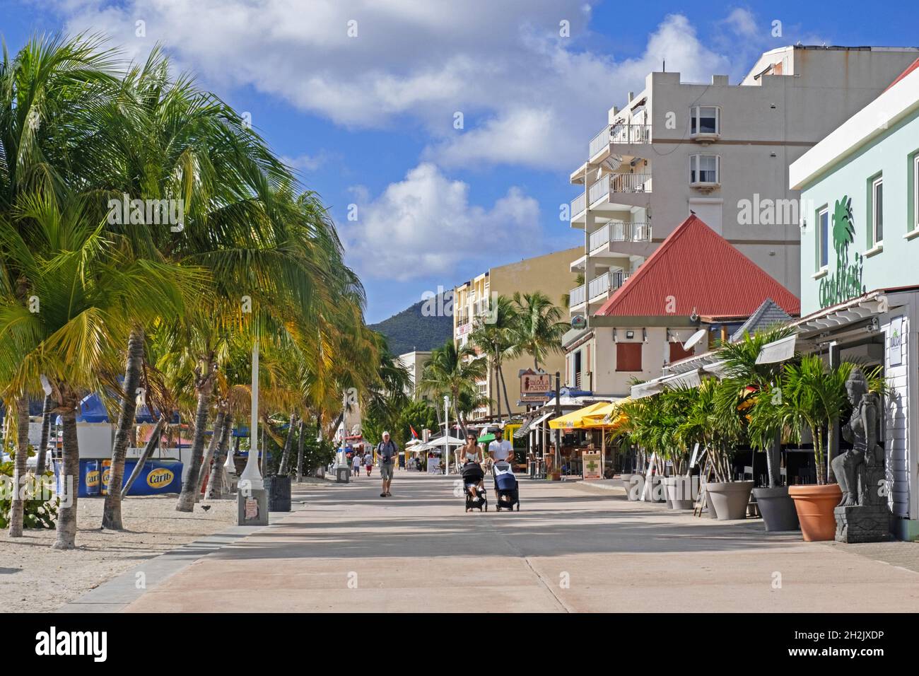 Touristen, die auf einem Boulevard mit Palmen entlang des Strandes in der Hauptstadt Philipsburg der niederländischen Insel Sint Maarten in der Karibik spazieren Stockfoto