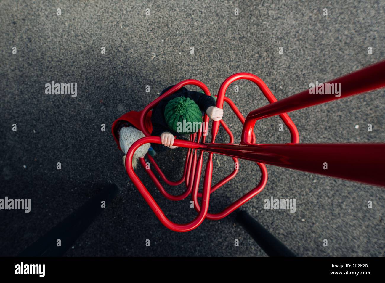 Kinder auf dem roten Spielplatz klettern am Frühlingstag Stockfoto