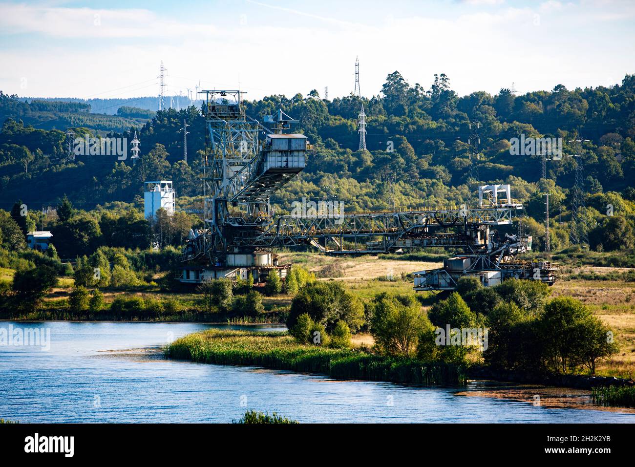 Verlassene Bergbaumaschine neben einem See Stockfoto