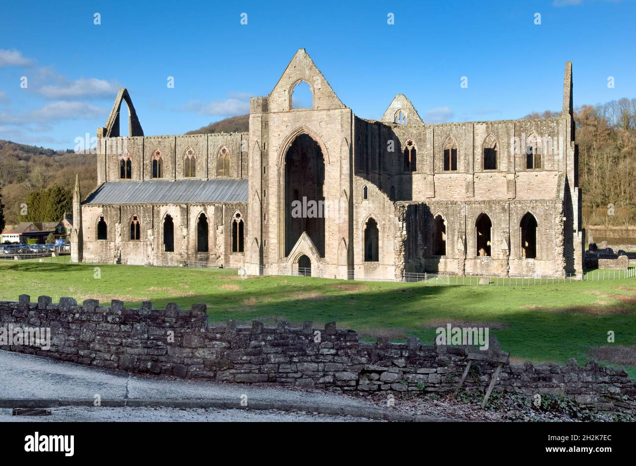 Tintern Abbey im Wye Valley in Monmouthshire, großbritannien an einem sonnigen Wintertag mit Frost im schattigen Bereich und blauem Himmel dahinter Stockfoto