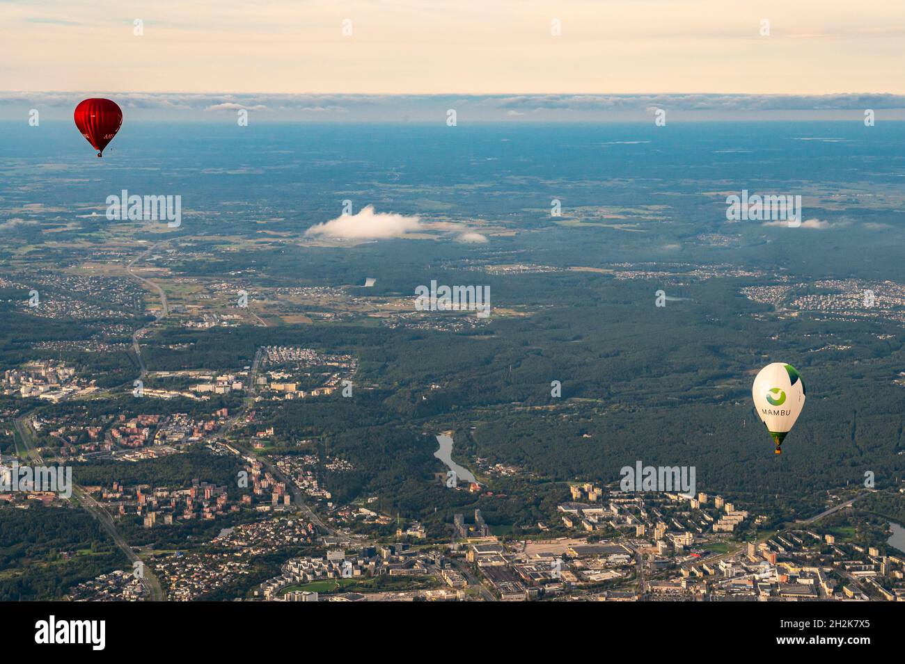 Vilnius, Litauen - 14. September 2021: Weiße und rote Heißluftballons fliegen über der litauischen Hauptstadt Vilnius. Blick vom Himmel auf die Stadt Vilnius Stockfoto