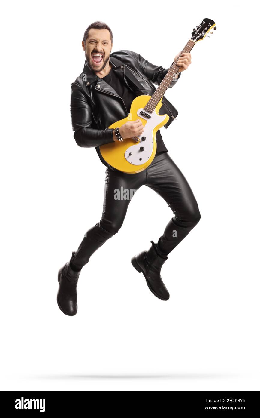 Mann in Lederkleidung spielt eine E-Gitarre und springt isoliert auf weißem Hintergrund Stockfoto