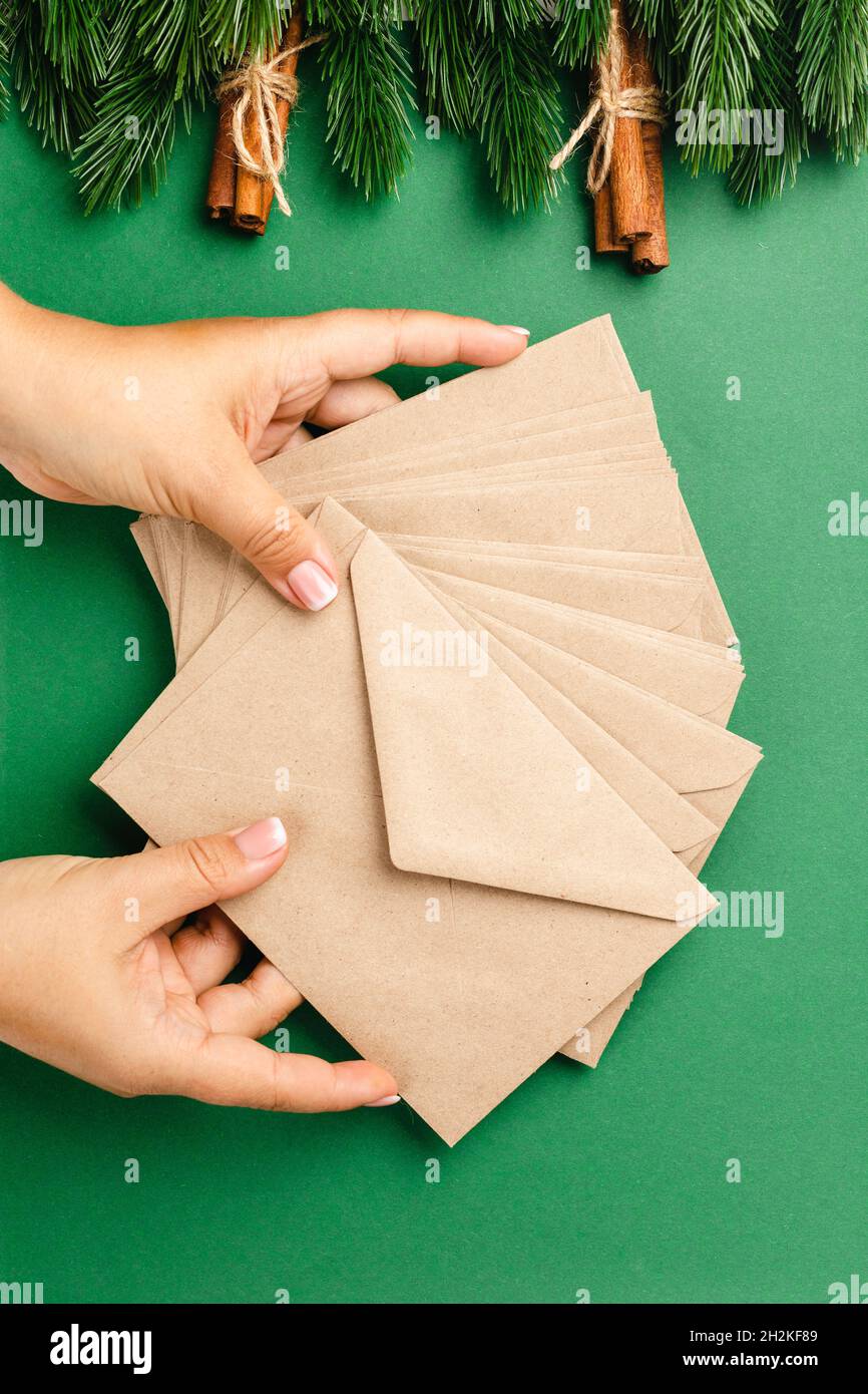 Frau Hände halten Stapel von Handwerk beige Umschläge, Konzept des Versands Weihnachtsgrüße Stockfoto