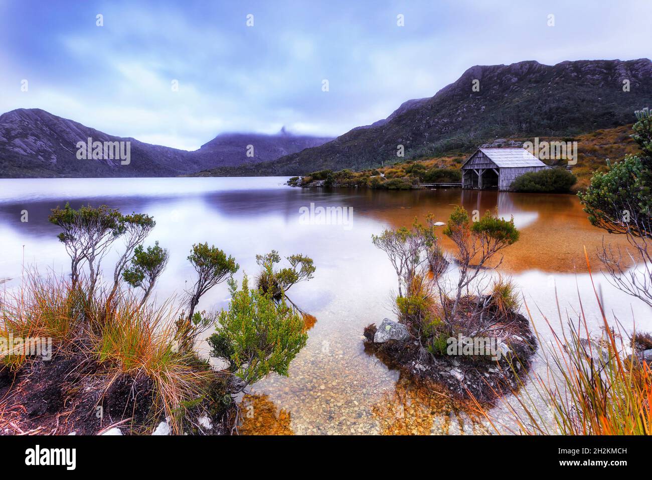 Unberührtes Süßwasser in Dove Lake mit Quarzsteinstrand in der Nähe von boatshed mit Blick auf den Cradle Mountain. Stockfoto