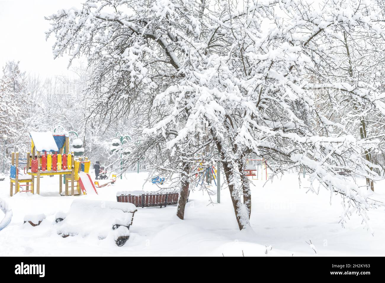 Winterlandschaft in Moskau, Russland. Landschaft mit verschneiten Bäumen und Spielplatz. Malerische Aussicht auf den leeren Stadtpark unter Schnee. Stadt während Schneefall für backgro Stockfoto