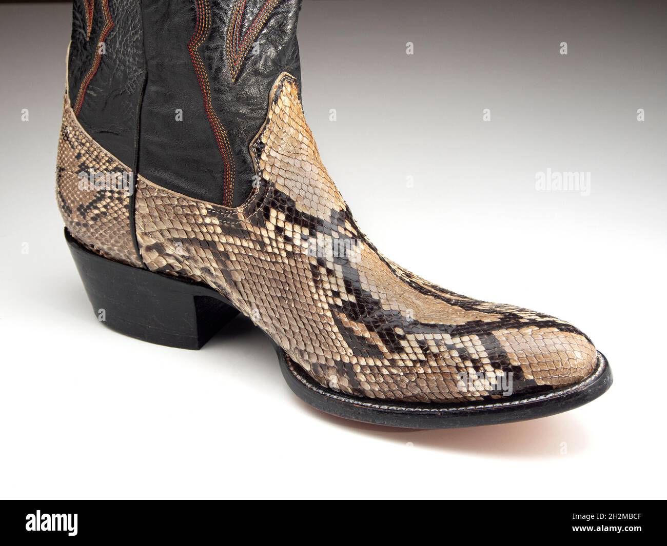 Cowboystiefel aus der gebräunten Haut einer retikulierten Python (Malayopython reticulatus). Die Skalen, Farben und Markierungen sind unverwechselbar Stockfoto