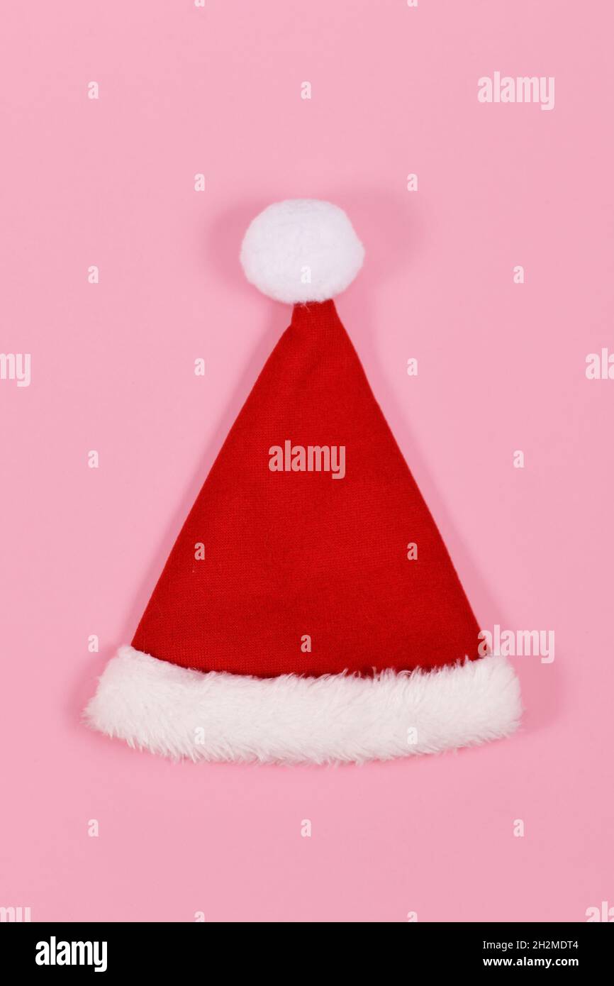 Single roten Weihnachtsmann Hut auf rosa Hintergrund Stockfoto