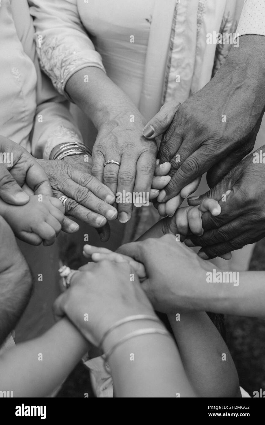 Multirassische Gruppe mit schwarzen afroamerikanischen kaukasischen und asiatischen Händen halten sich gegenseitig Handgelenk in Toleranz Einheit Liebe und Anti-Rassismus Stockfoto