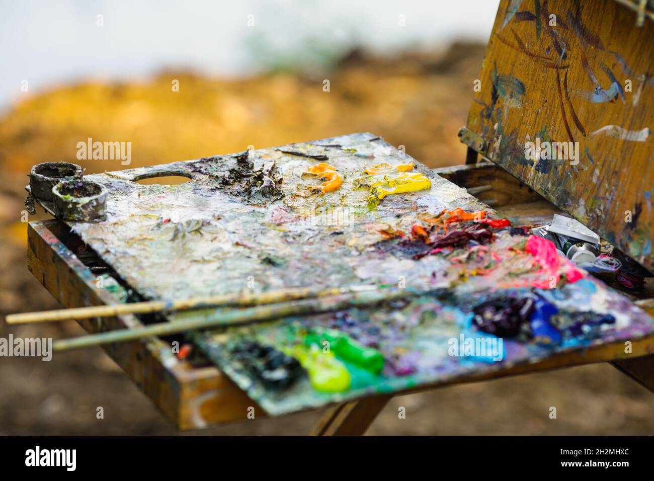 Bild mit geringer Schärfentiefe (selektiver Fokus) und einer Farbpalette für Maler, während an einem sonnigen Herbsttag eine Landschaft gemalt wird. Stockfoto