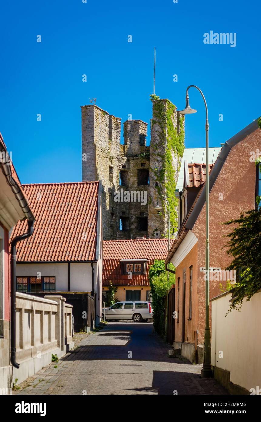 Straße in Visby mit Turmruinen im Hintergrund. Stockfoto
