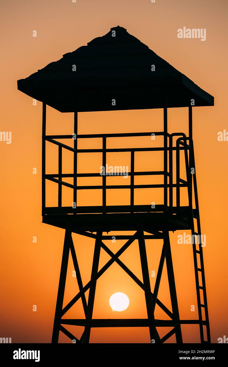 Rettungsschwimmer Tower Silhouette Am Strand Bei Sonnenuntergang. Sonne Sonnenschein Durch Den Lifeguard Tower Bei Sonnenaufgang Im Sommer Stockfoto