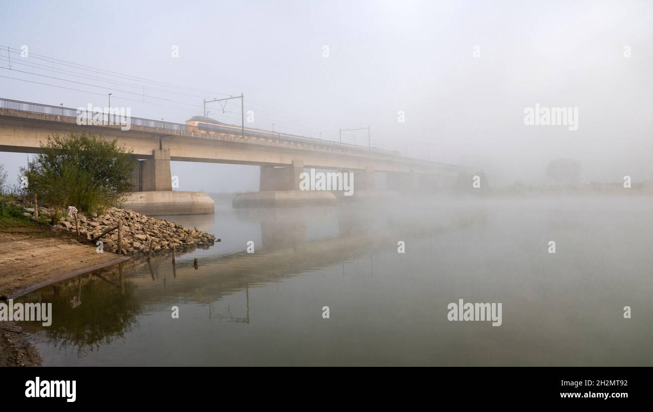 Eisenbahnbrücke verschwindet im Nebel. Stockfoto