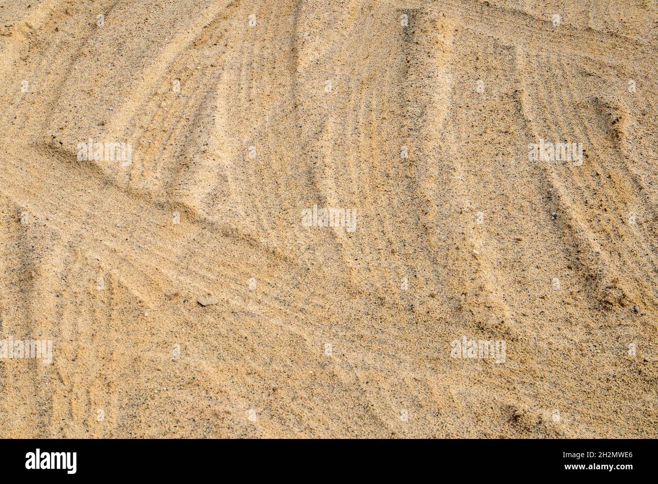 Leichter Sand, der von Reifenspuren zertrampelt wird, kann als Hintergrund oder Textur verwendet werden Stockfoto