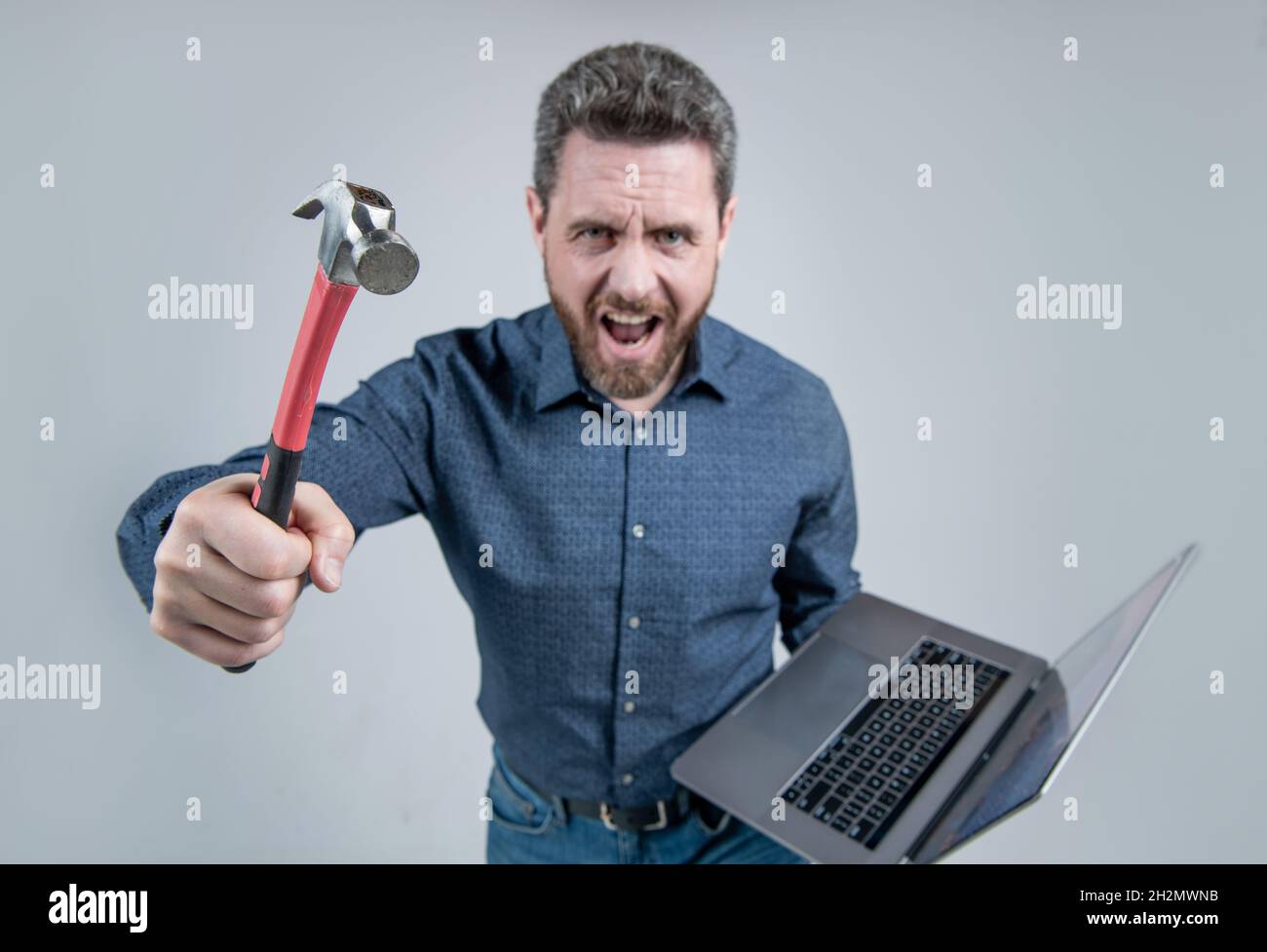 Aufgabe konnte nicht abgeschlossen werden. Wütender Mann, der Hammer und Laptop hält. Computerrage. Wütend Stockfoto