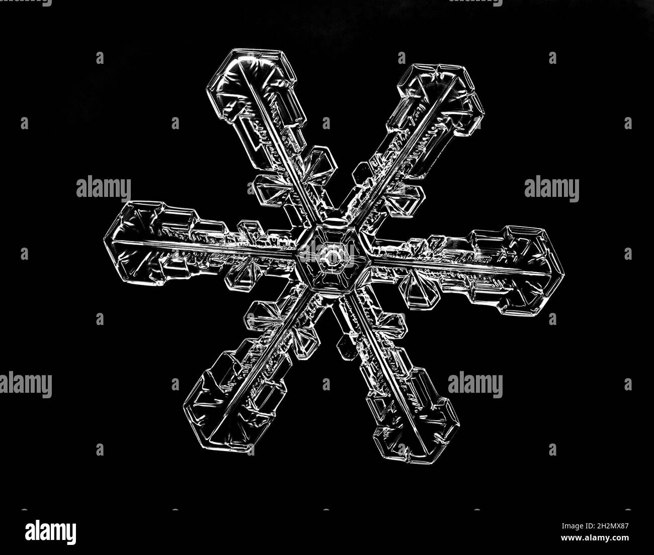 Weiße Schneeflocke isoliert auf schwarzem Hintergrund. Illustration basierend auf Makrofoto von echtem Schneekristall: Elegante Sternplatte mit kurzen, breiten Armen Stockfoto