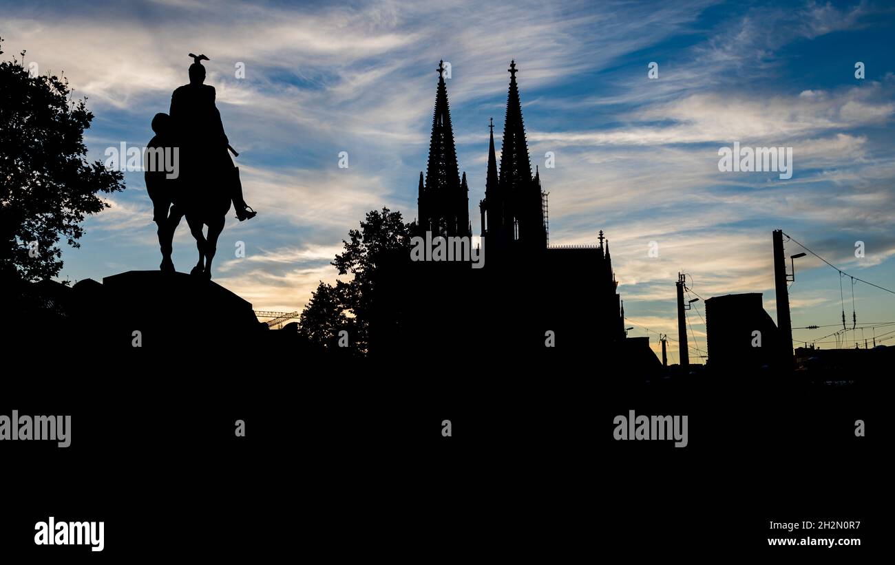 Schwarze Silhouette des Kölner Doms und der Reiterstatue Kaiser Wilhelm