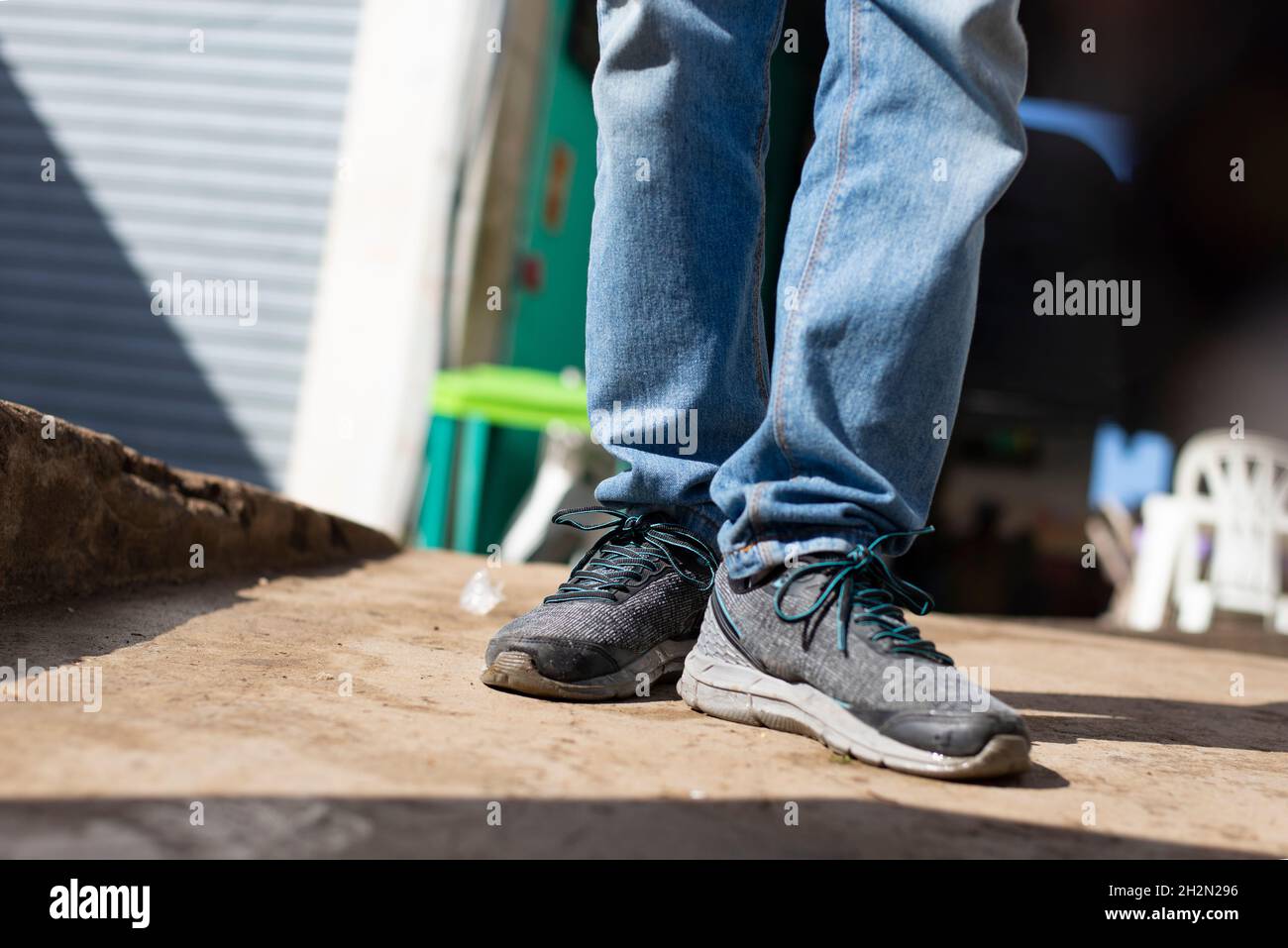 Schuhe und Hosen einer Person, die vor dem Eingang zur Messe in Sao Joaquim steht. Salvador Bahia Brasilien. Stockfoto