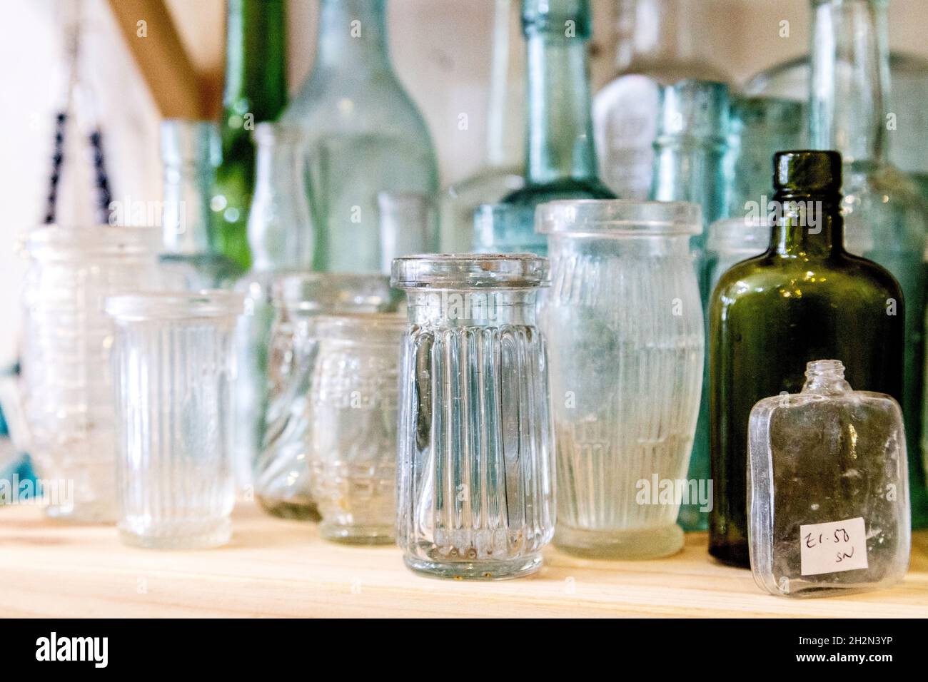 Alte Glasflaschen, ausgestellt in einem Antiquitätengeschäft (Hampton Court Emporium, East Molesay, UK) Stockfoto