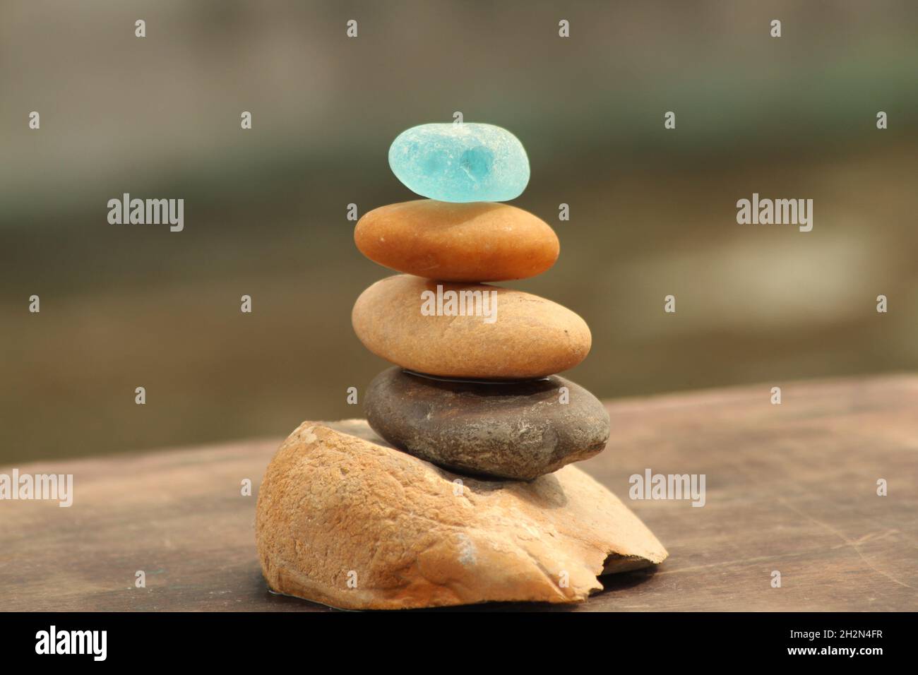 Verschiedene Arten von Steinkieseln und Seeglaswaagen auf einer Holzdiele Stockfoto
