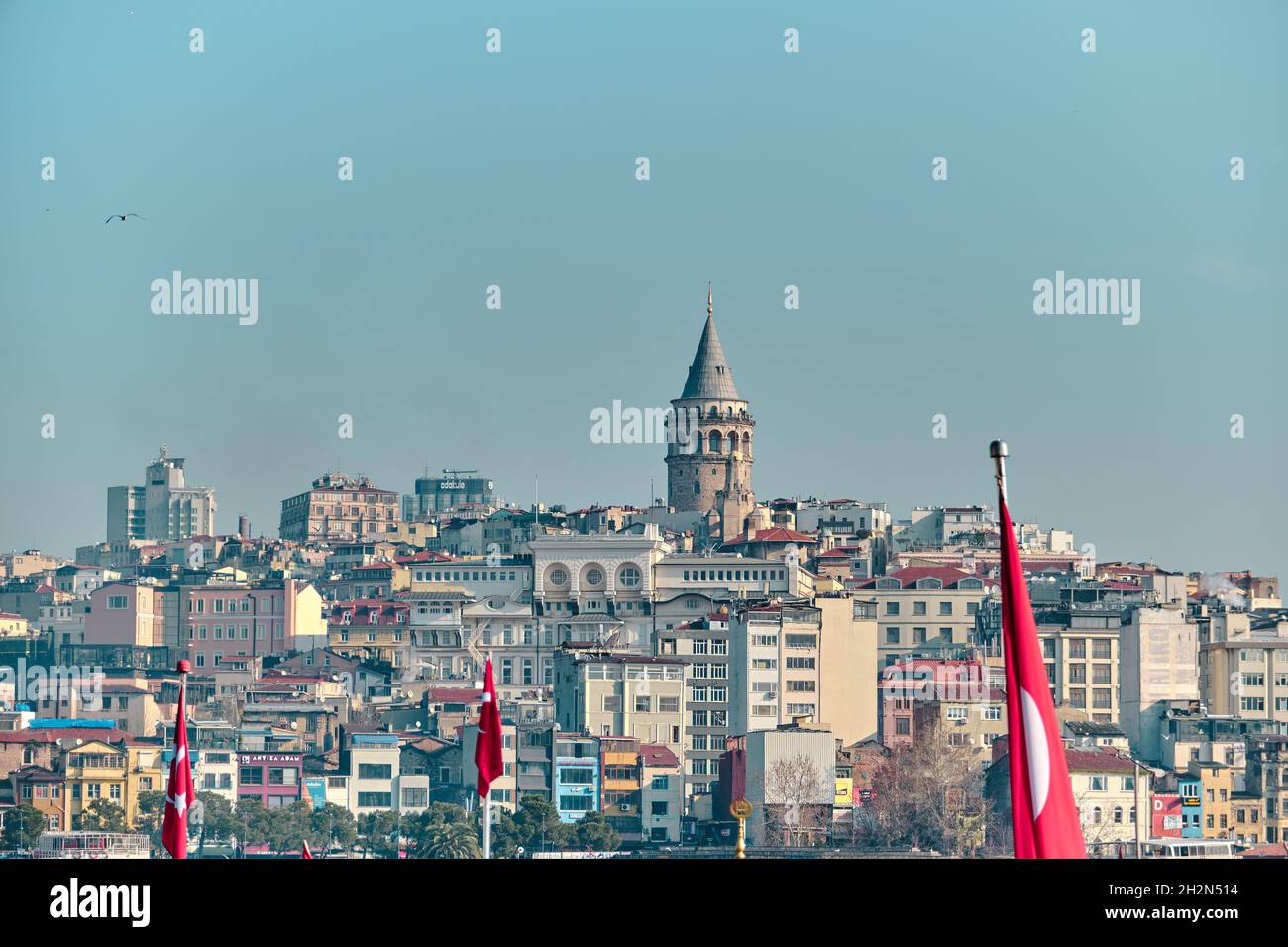 Der berühmte galata-Turm von istanbul wurde von istanbul bosphorus und eminonu mit vielen türkischen Flaggen während regnerischer Tage und bewölktem Himmel fotografiert. Stockfoto